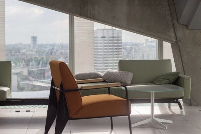 An orange chair in a room overlooking a city, perfect for a mental health therapist.